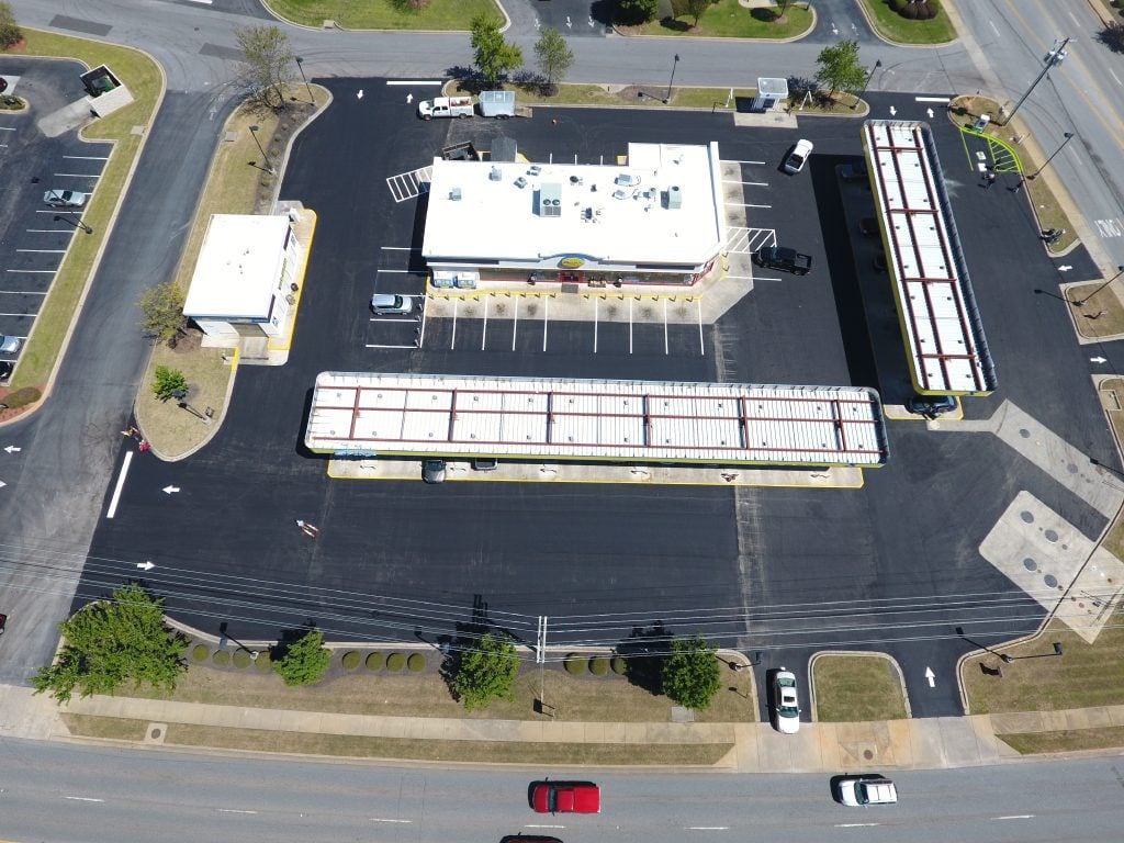 Freshly sealcoated and striped commercial pad site, aerial view