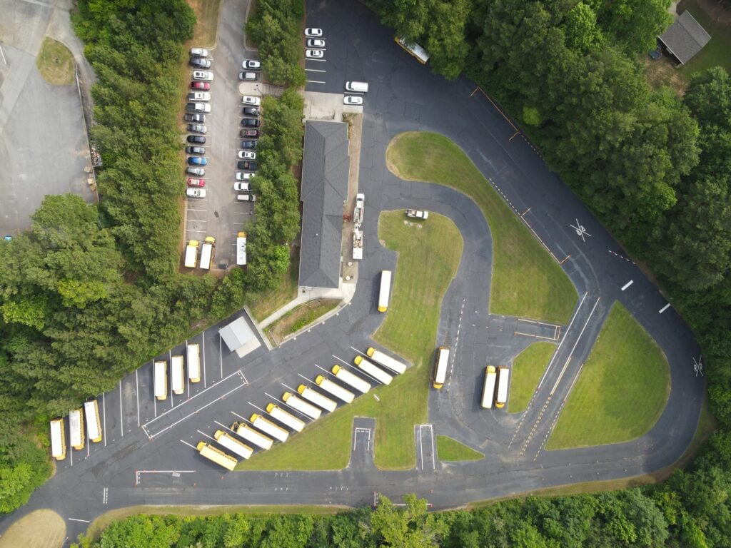 Fleet parking yard with fresh asphalt repairs and new striping, aerial view